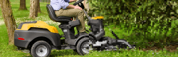 Stiga Lawnmower with a combi deck, mowing underneath a bush, half of the image is pixalated
